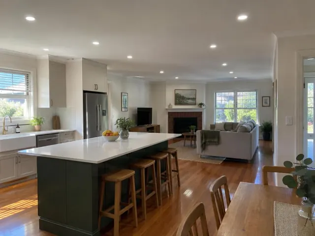Open-plan kitchen and living room with recessed ceiling downlights, timber floors and island in Hexham